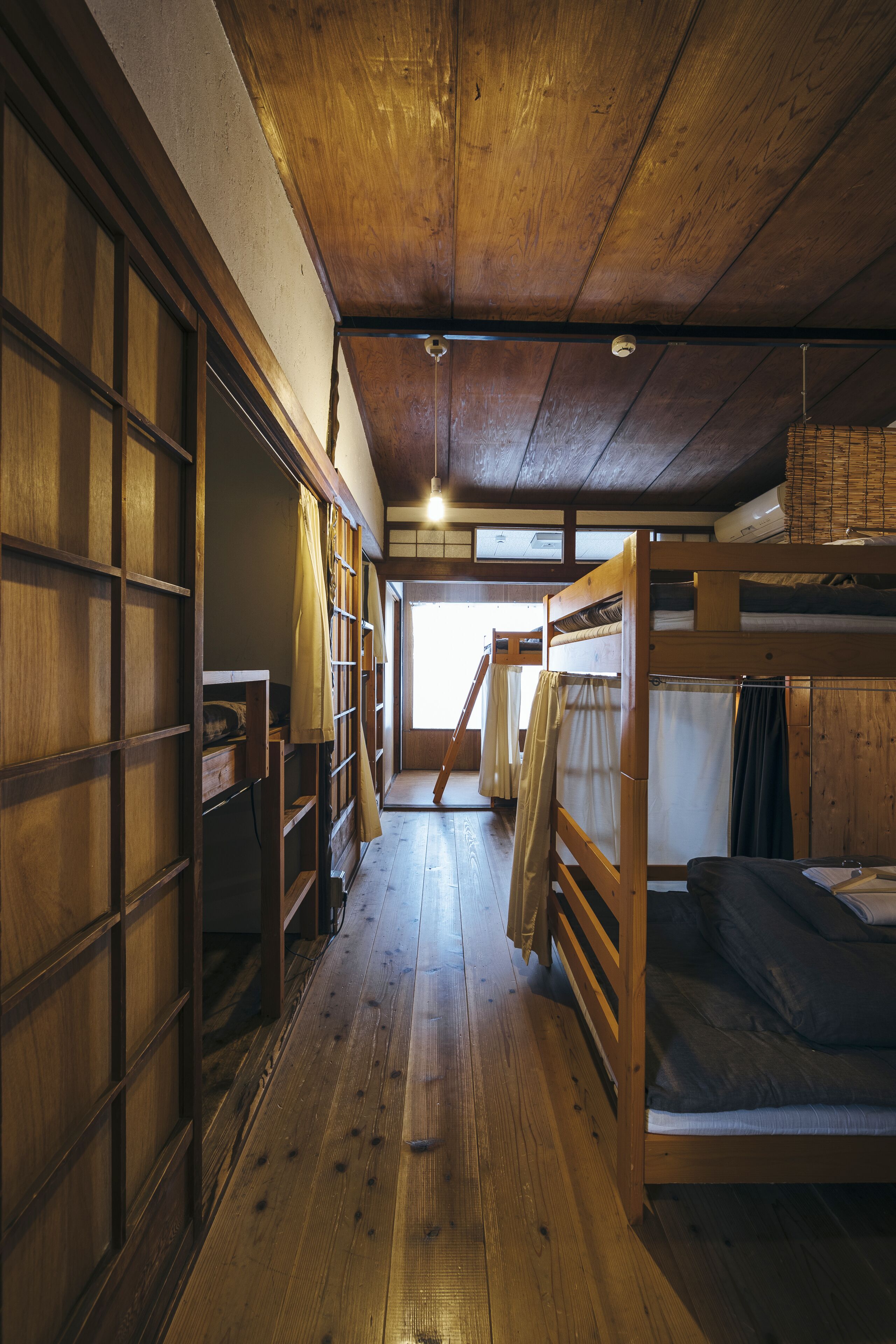 Un interior rústico de madera con literas y piso de madera.