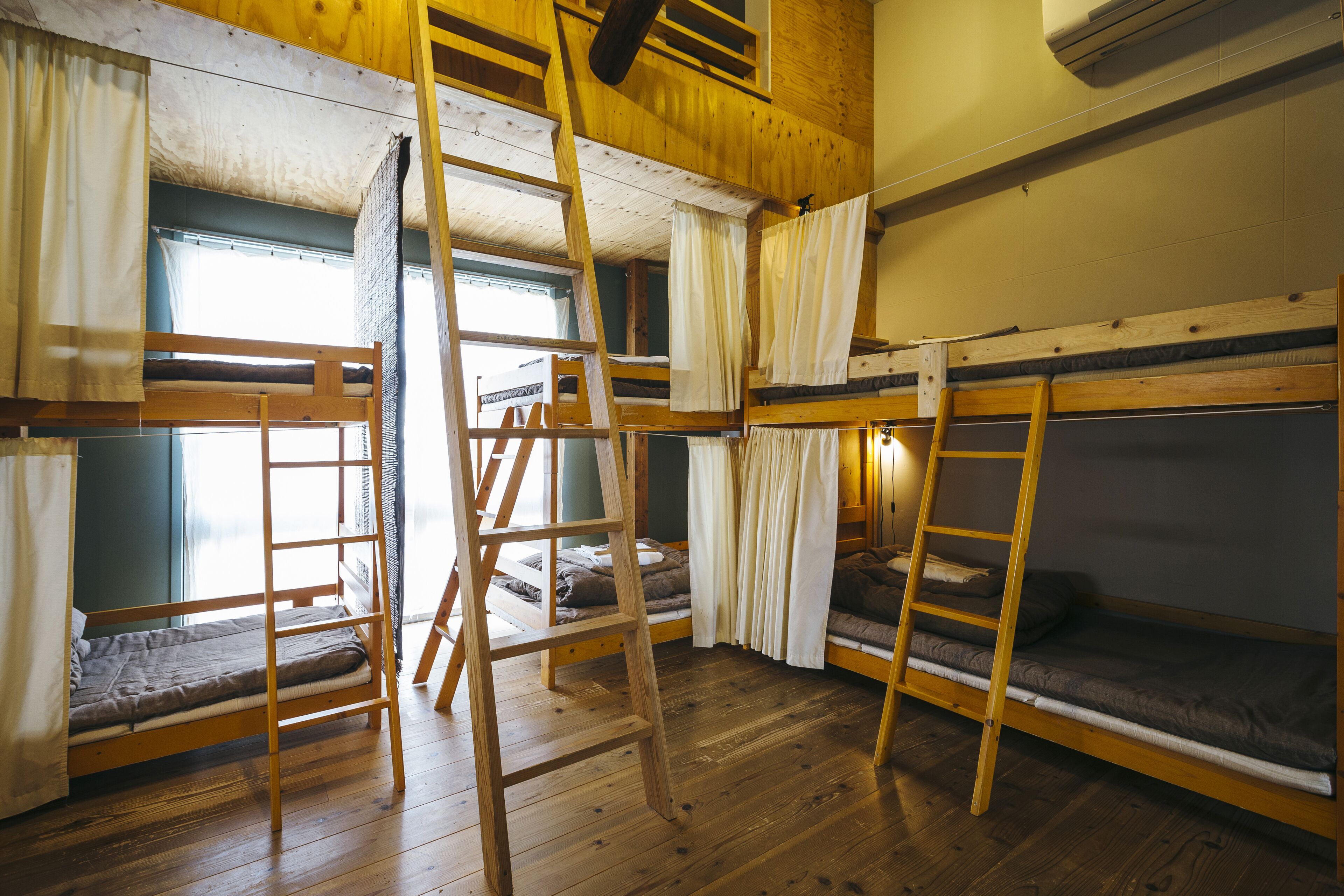Un dormitorio con literas, suelo de madera y una escalera.
