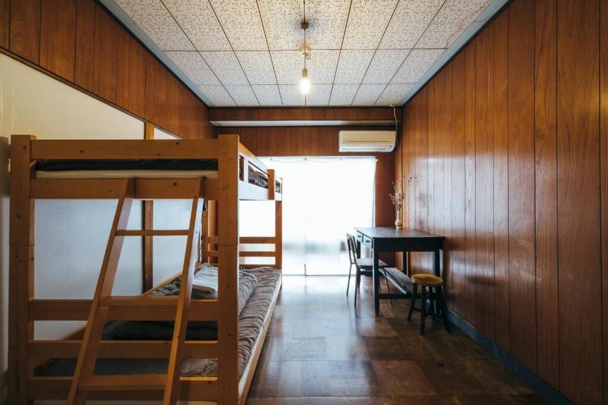 A room with a bunk bed, a desk, and a chair.