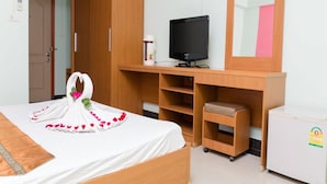 A hotel room with a bed, a TV, a desk, and a wardrobe. - The Garden Place (Nonthaburi)