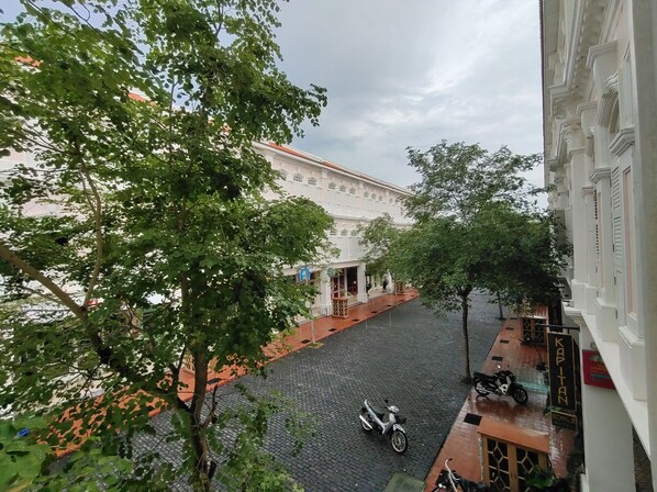 Una calle estrecha con un edificio de arquitectura tradicional y un letrero que dice "KAPITAN".