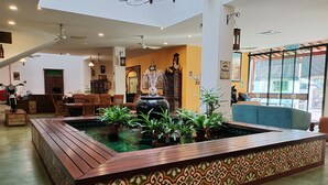 Un vestíbulo amplio con una fuente central, asientos de madera y un ventanal que ofrece vistas al exterior.