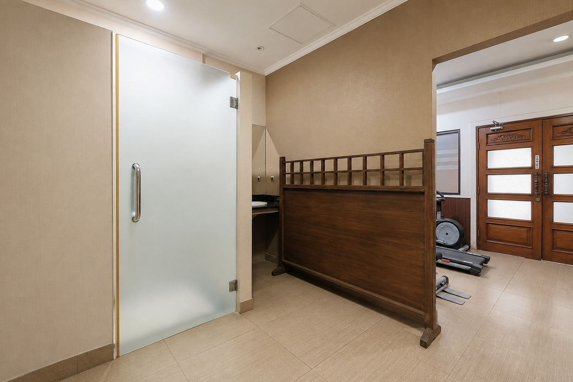 A room with a bed, a wardrobe, and a treadmill.