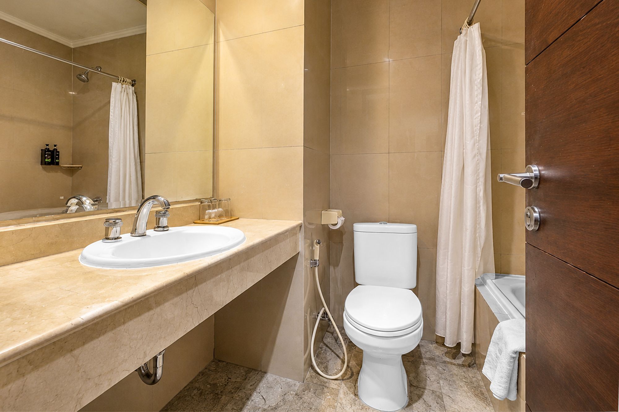 Ein Badezimmer mit Waschbecken, Spiegel, Toilette, Duschvorhang und Handtuchhalter.