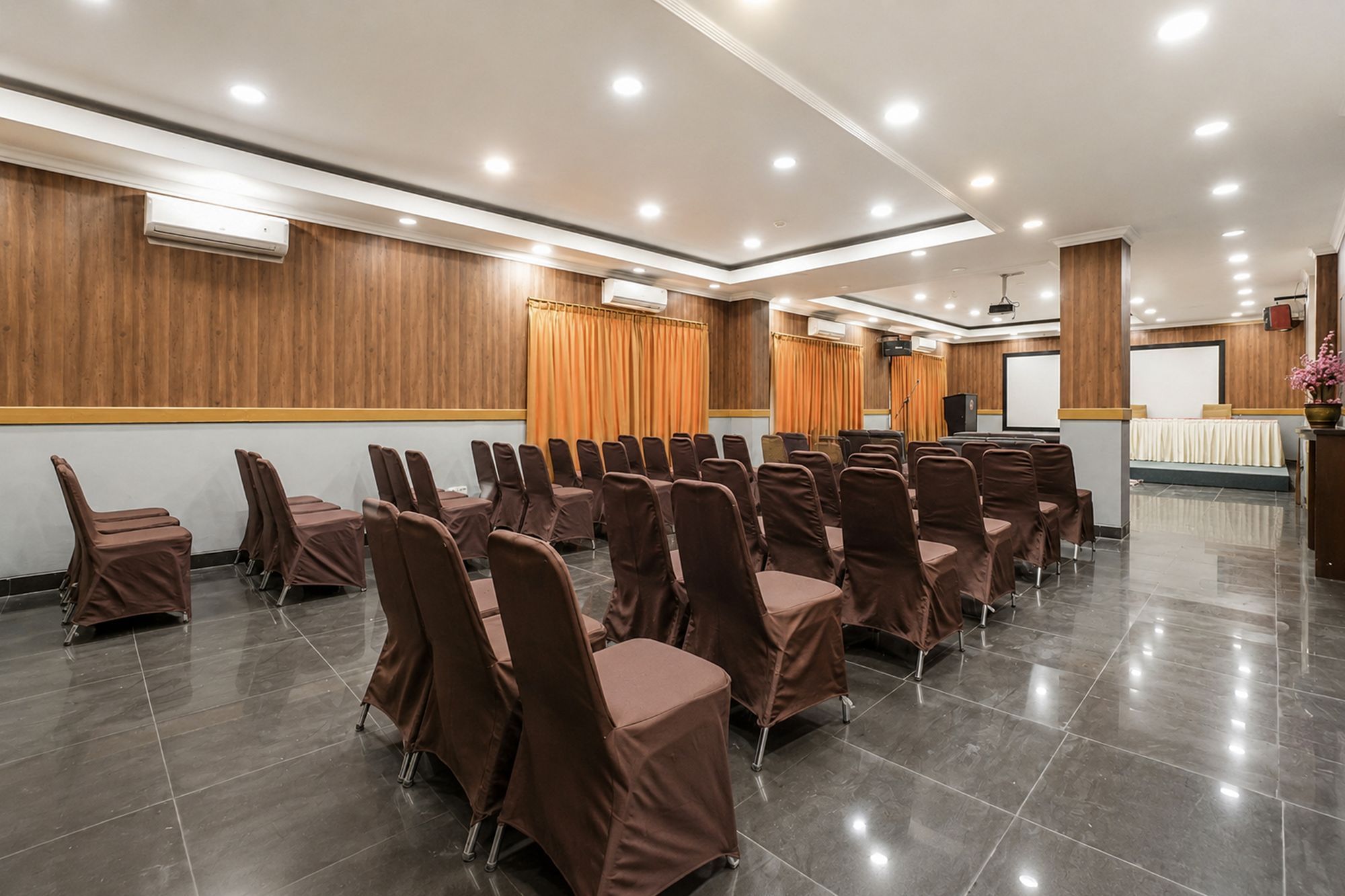 A conference room with rows of chairs, a podium, and a projection screen.