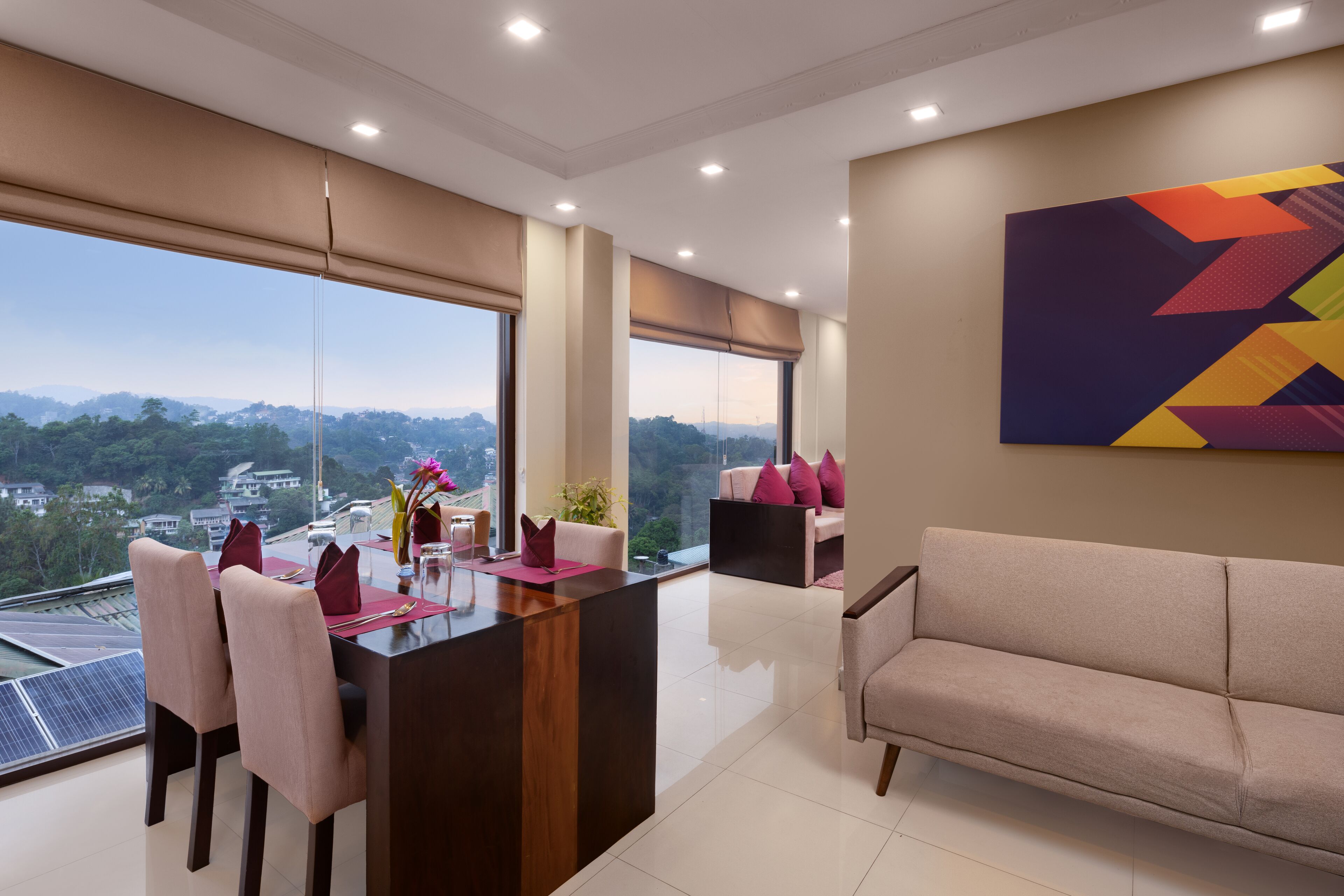 Un salon moderne avec un coin repas, de grandes fenêtres et une vue sur la ville.