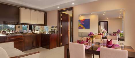 A modern kitchen with dark wood cabinets, a central island, and a dining area with a table set for four.