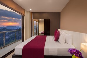 A modern hotel room with a large bed, a balcony with a city view, and a large window.