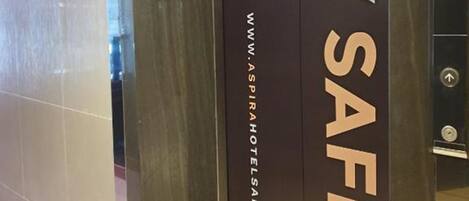 Entrada de un hotel con un cartel que dice 'Stay Safe' y la página web www.aspirahtelsandresorts.com.