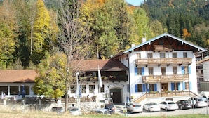 A hotel with a traditional Alpine architectural style, featuring a prominent balcony and a stone facade. - Gasthof Oberwirt (Fischbachau)