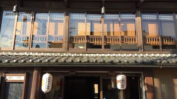 A traditional Japanese building with a wooden facade, large windows, and a tiled roof.