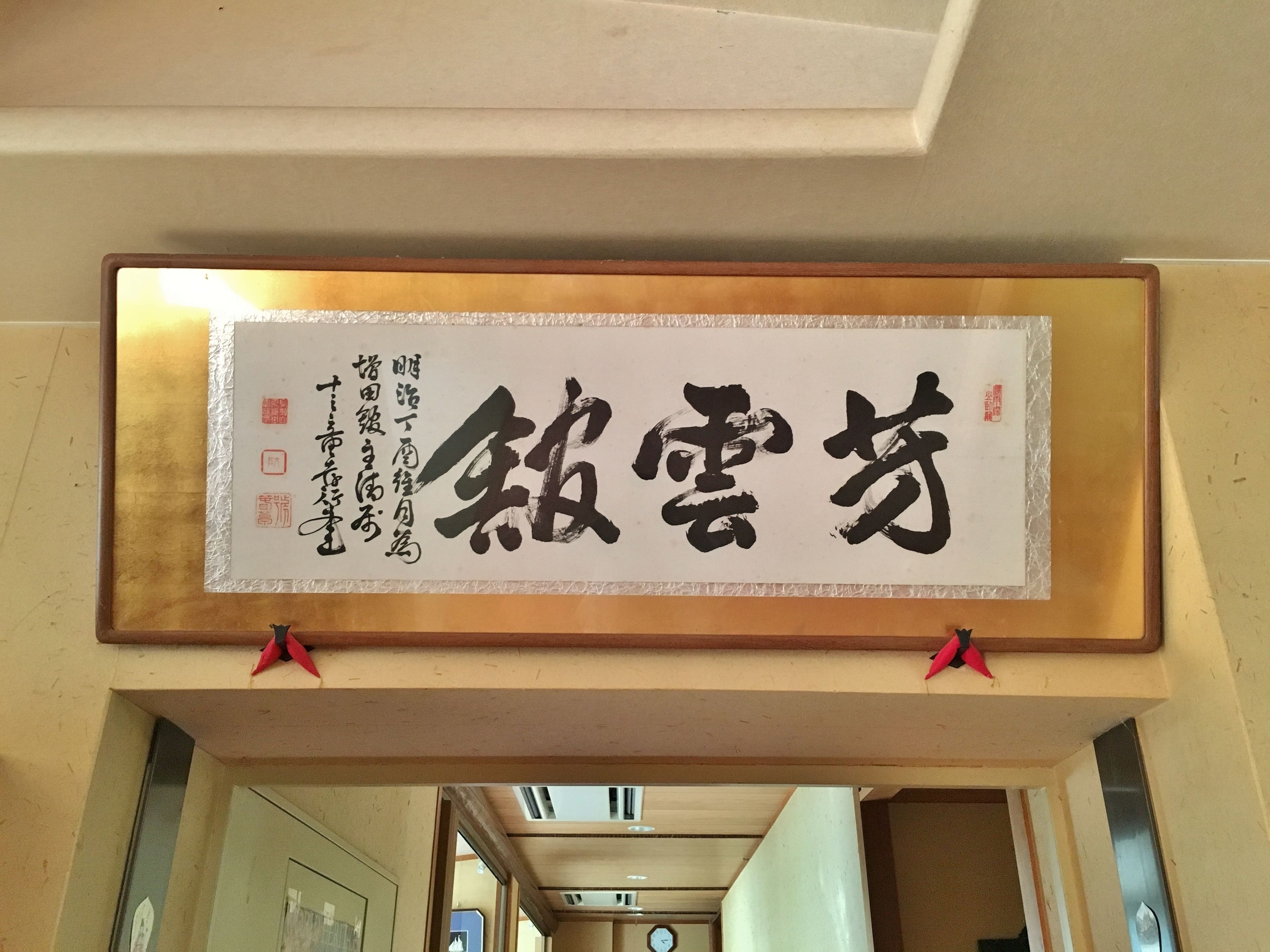 Un letrero caligráfico enmarcado con caracteres japoneses.