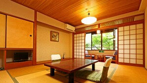 A tatami mat room with a low table, chairs, and a sliding door. - Hounkan (Yoshino)