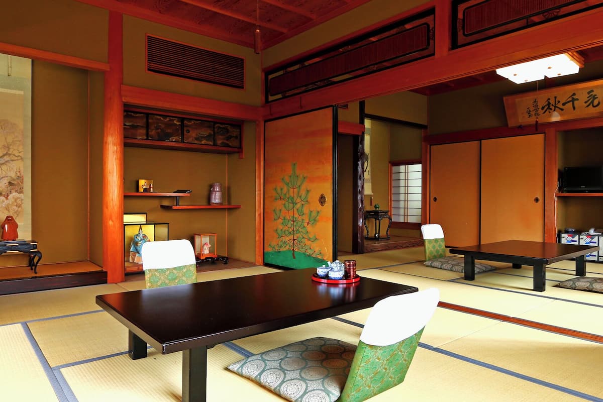 Une pièce de style japonais traditionnel, avec un sol recouvert de tatamis, une table basse et des paravents en papier.