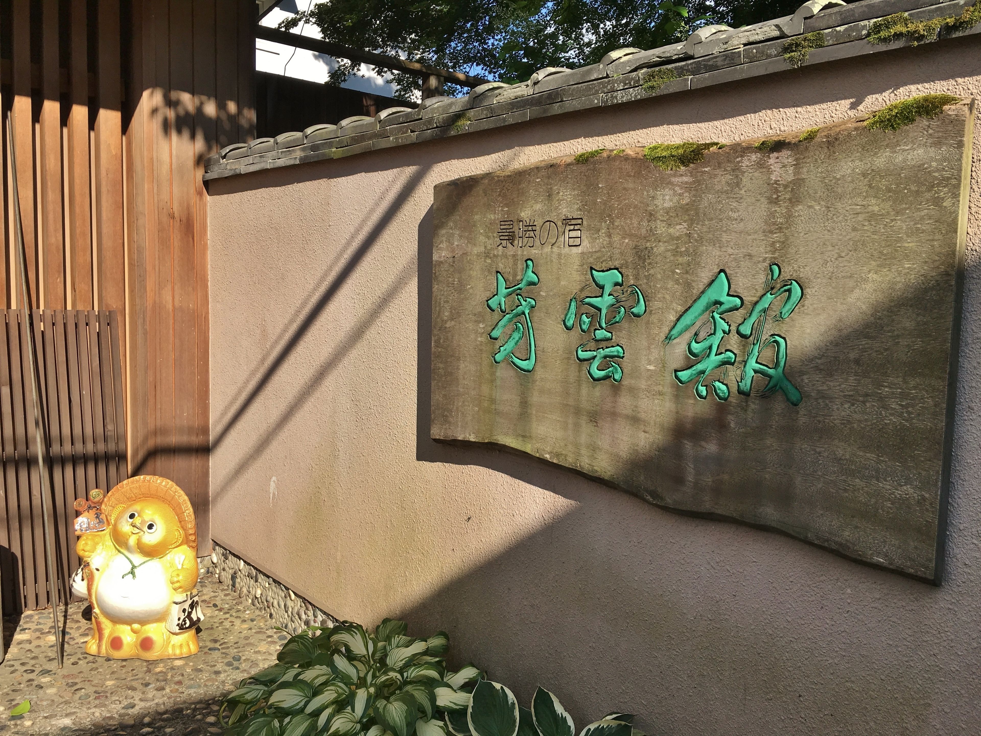 A stone wall with a sign in Japanese characters.