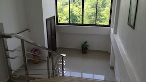 Una escalera conduce a un balcón con vistas a zonas verdes.