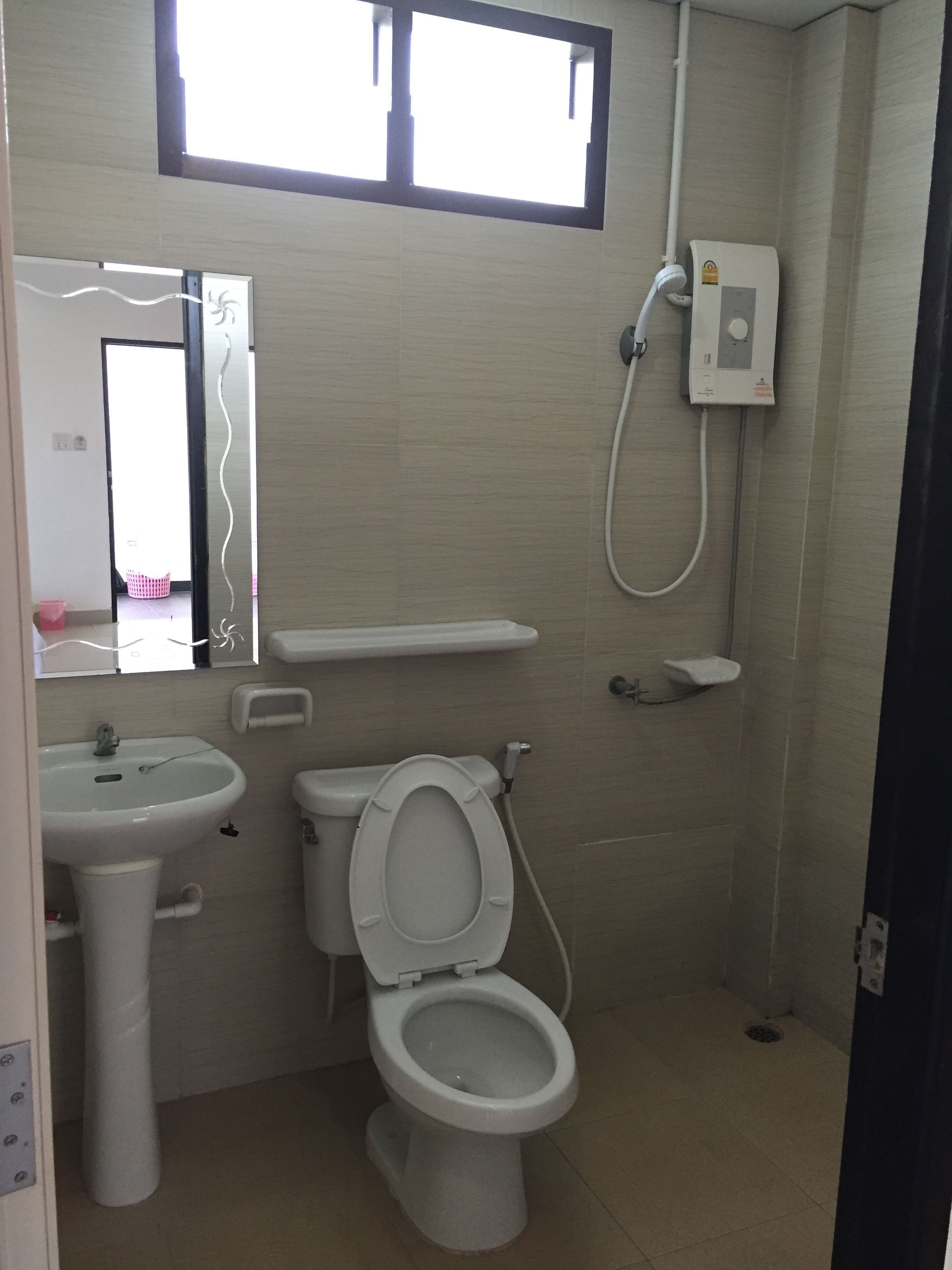 A small, clean bathroom with a toilet, sink, and shower.