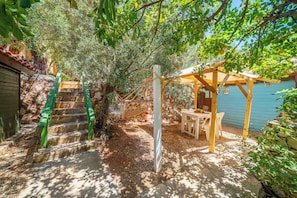 A wooden pergola with a table and chairs, a stone staircase with green railings, and a wooden fence in a garden setting. - Olympos Mocamp Kas (Kas)