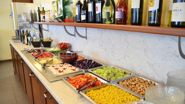 Un buffet proposant une variété de plats et une sélection de bouteilles de vin exposées sur le comptoir.