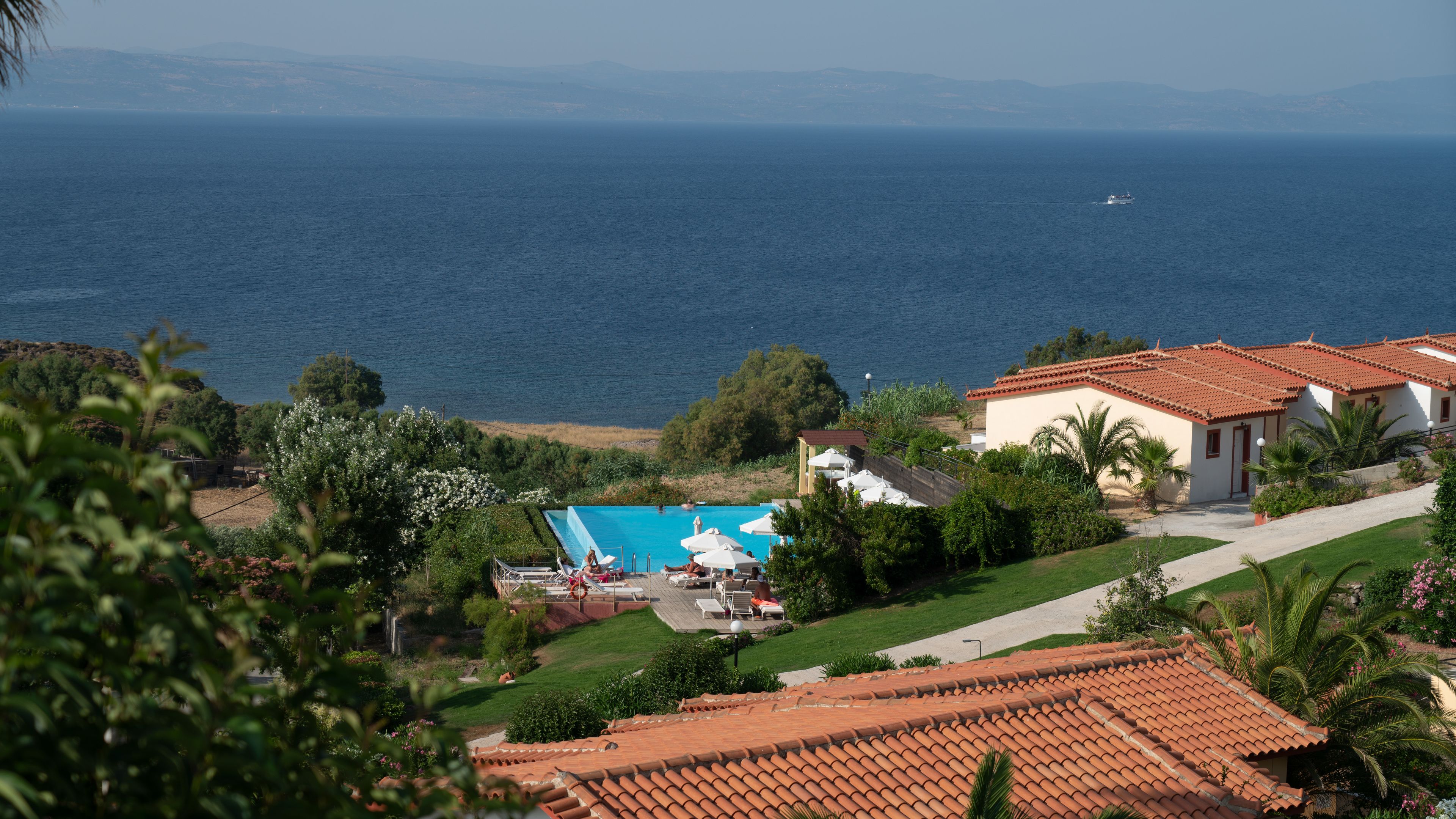 Propiedad costera con piscina, zona de patio y vista al mar.