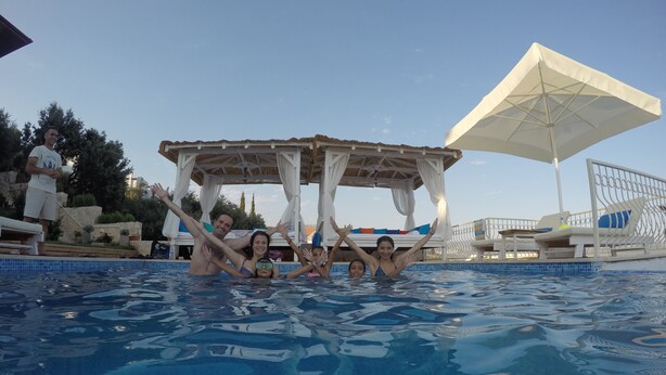 A swimming pool with a gazebo structure, lounge chairs, and an umbrella. - Hotel Marsala (Kas)