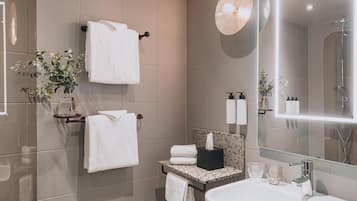 A modern bathroom with a large mirror, a sink, and a towel rack.