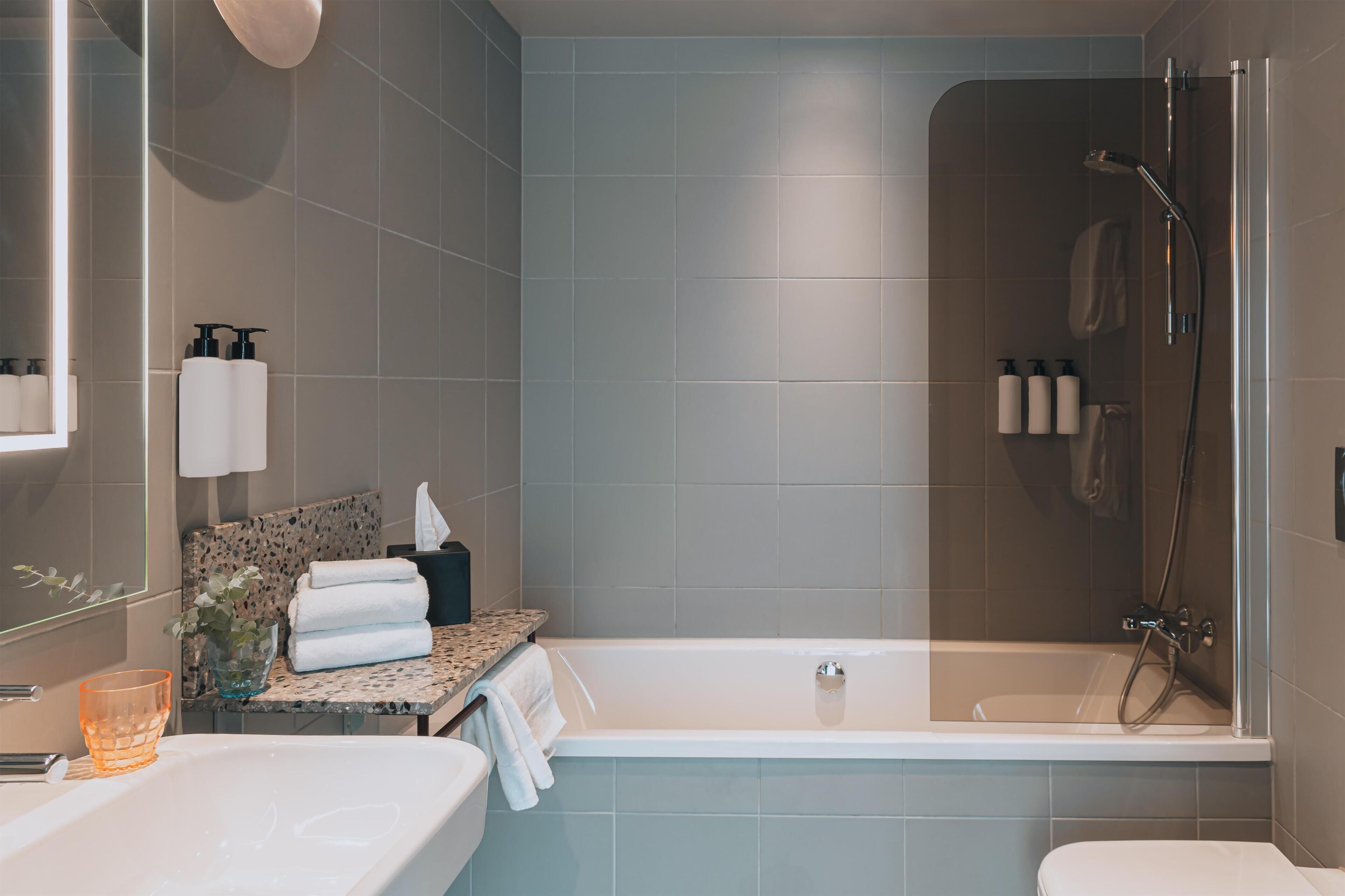 Une salle de bain moderne avec une baignoire, une douche et un lavabo.