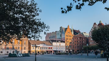 A historic building with a red facade, large windows, and a prominent clock tower.
