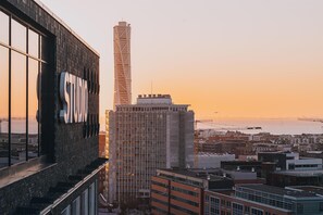 A cityscape with a prominent building featuring a large sign, a tall tower, and a view of the waterfront. - STORY HOTEL MALMO, in JdV by Hyatt (Malmö)