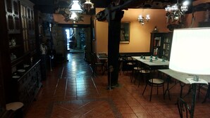 Un restaurant à l’agencement long et étroit, doté d’un sol carrelé et de nombreuses tables et chaises.