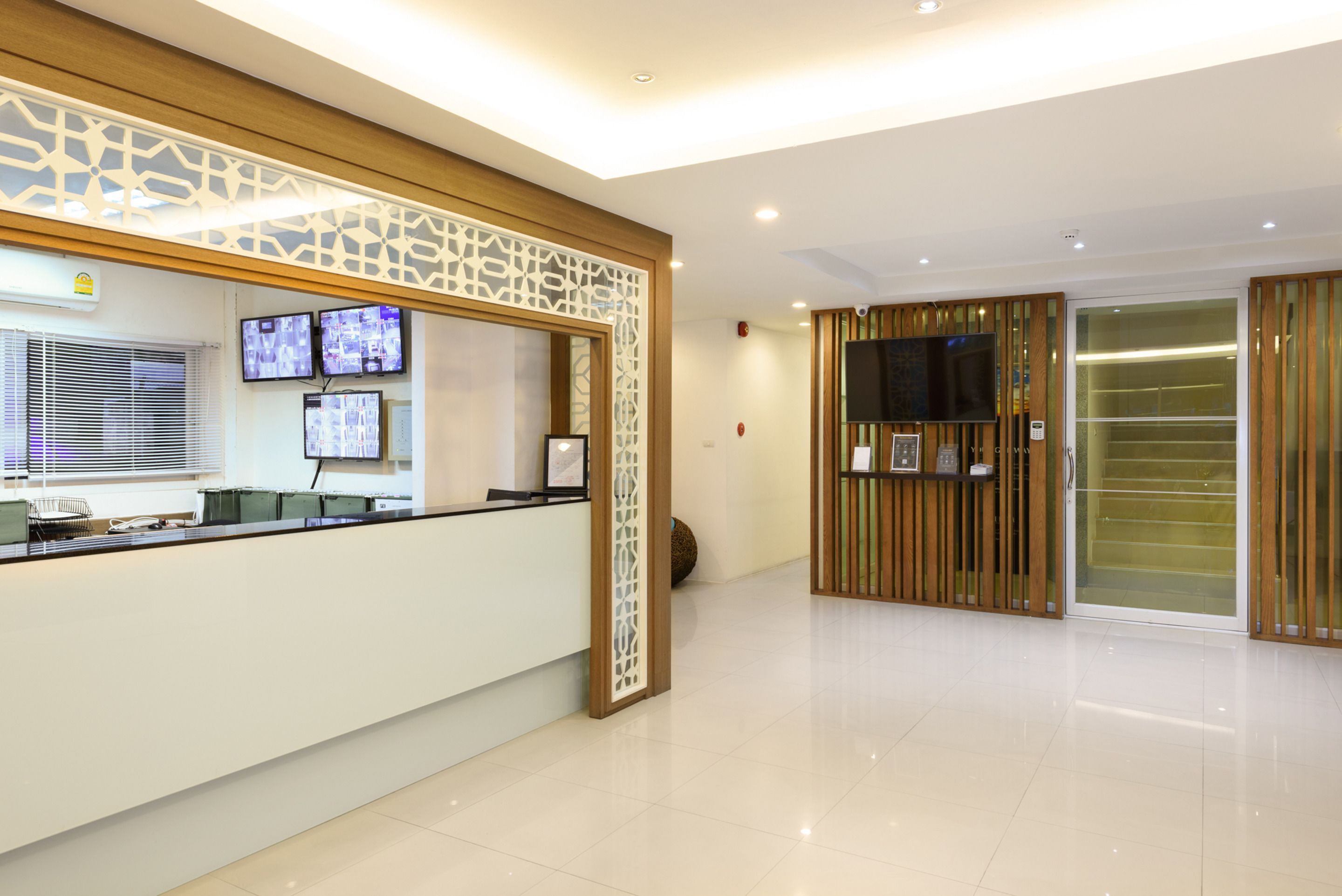 A modern reception area with a counter, multiple monitors, and a television.