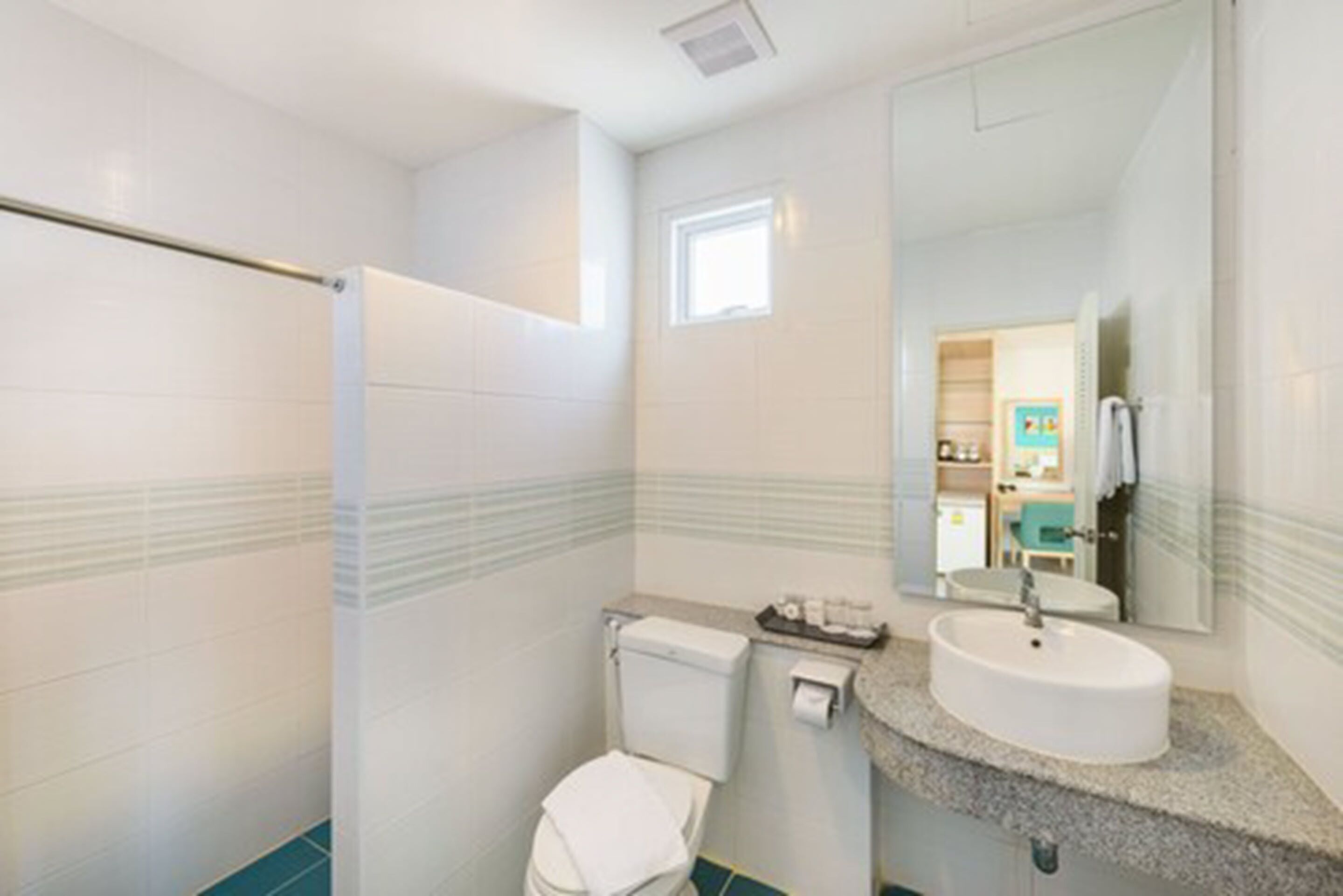 A bathroom with a toilet, sink, and shower.