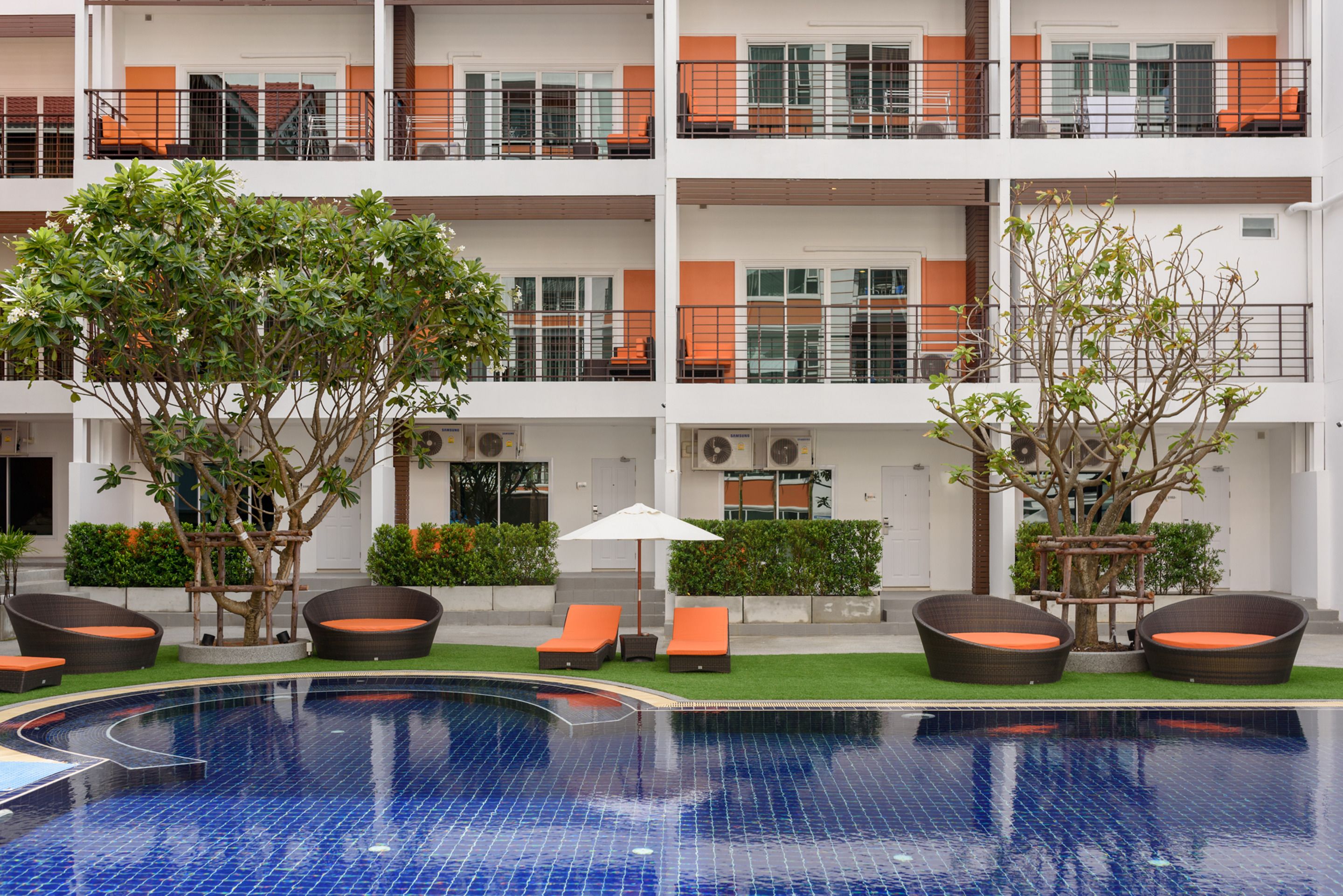 Un hôtel doté d’une piscine, d’un espace extérieur aménagé et de plusieurs balcons.