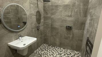 A modern bathroom with a shower, a sink, and a mirror.