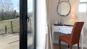 A room with a desk, chair, and a large window with a view of a grassy area. - The 3 Millstones Inn (Clitheroe)