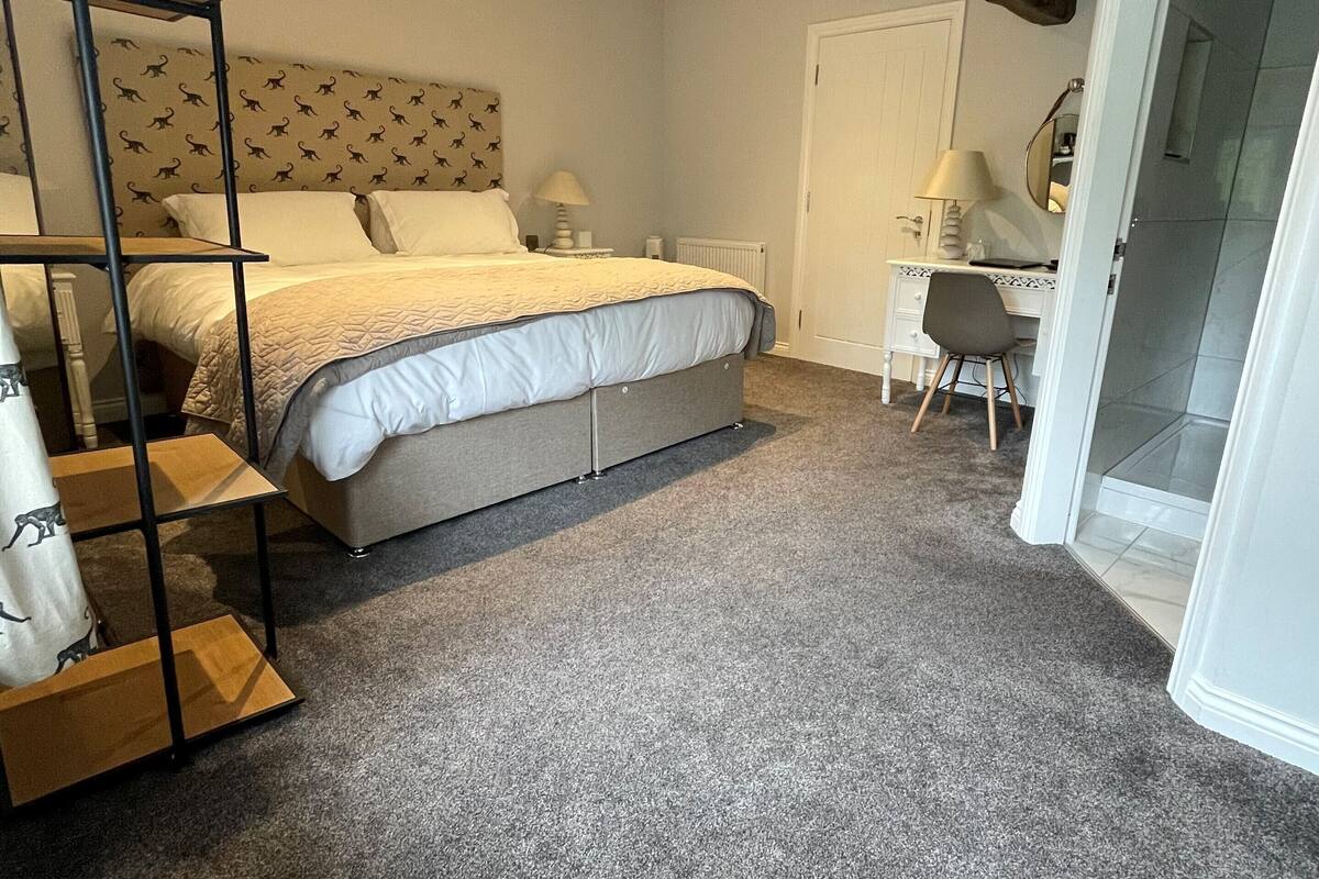 A bedroom with a bed, a desk, a chair, and a wardrobe.