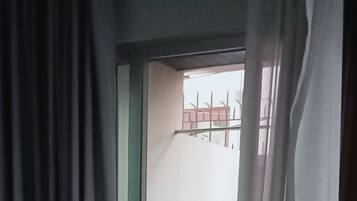 A room with a sliding glass door leading to a balcony.