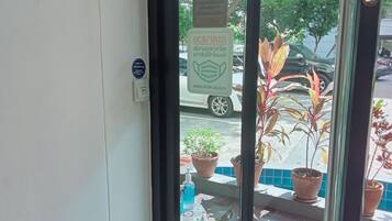 A door with a sign indicating a mask-wearing policy and a view of the street outside.
