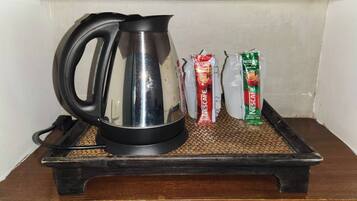 A coffee maker on a tray with two Nescafe coffee pods.