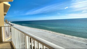 A balcony with a view of a beach and ocean.