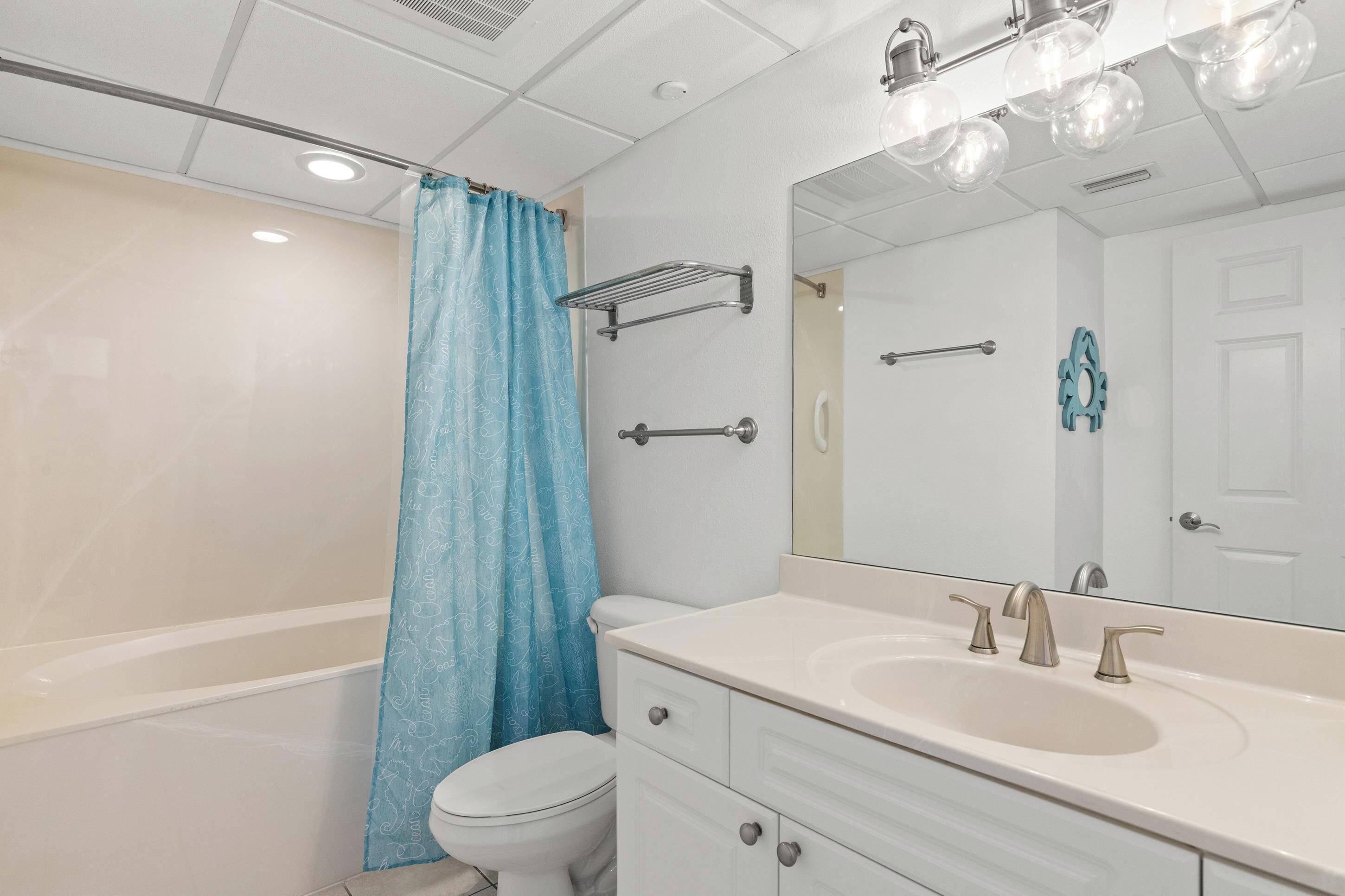 A modern bathroom with a bathtub, toilet, and sink.