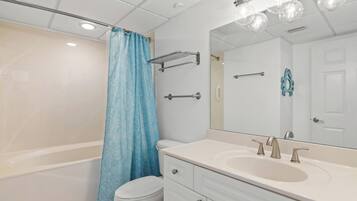 A modern bathroom with a bathtub, toilet, and sink.