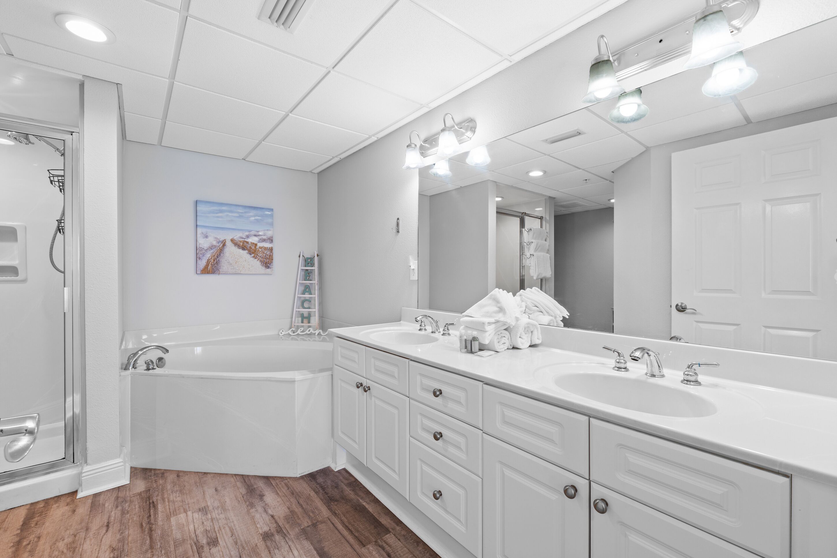 Une salle de bain moderne dotée d’une grande baignoire, de deux lavabos et d’une douche à l’italienne.