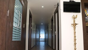 Un pasillo largo y estrecho con pisos de madera y puertas a ambos lados.