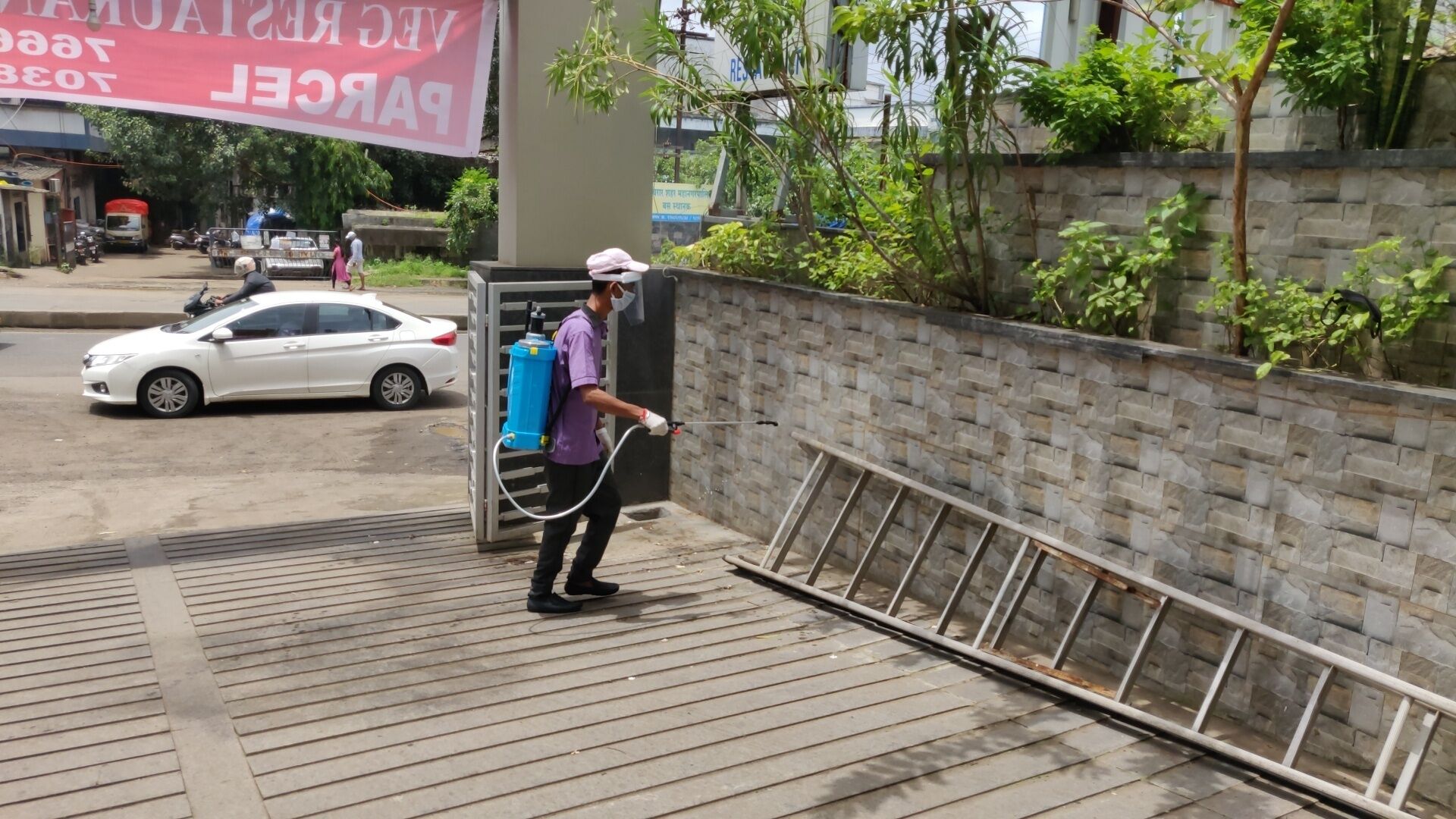 A person cleaning a metal railing with a pressure washer.