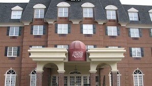 Ein Backsteinhaus mit einem Schild, auf dem „French Quarter Inn“ steht, und einer großen Kuppelstruktur im Vordergrund.