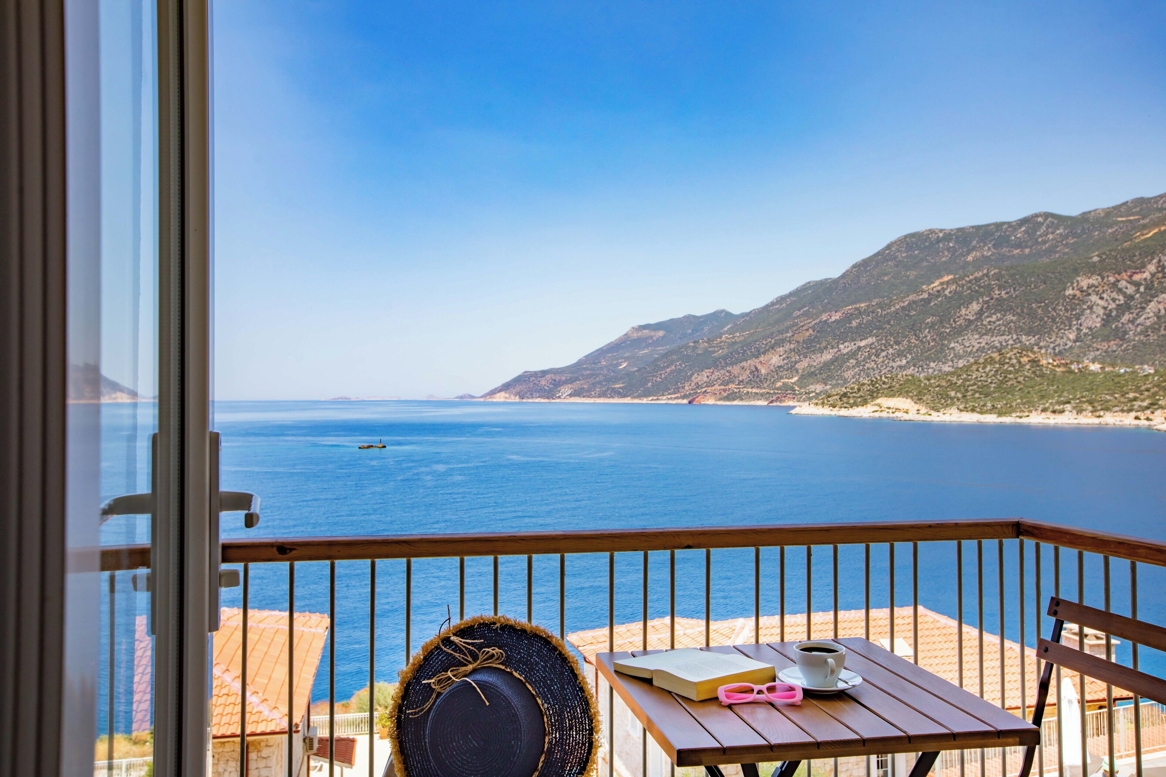 A balcony with a view of the sea and mountains.
