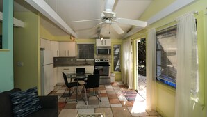 Una cocina compacta con comedor, ventilador de techo y ventana con persianas.