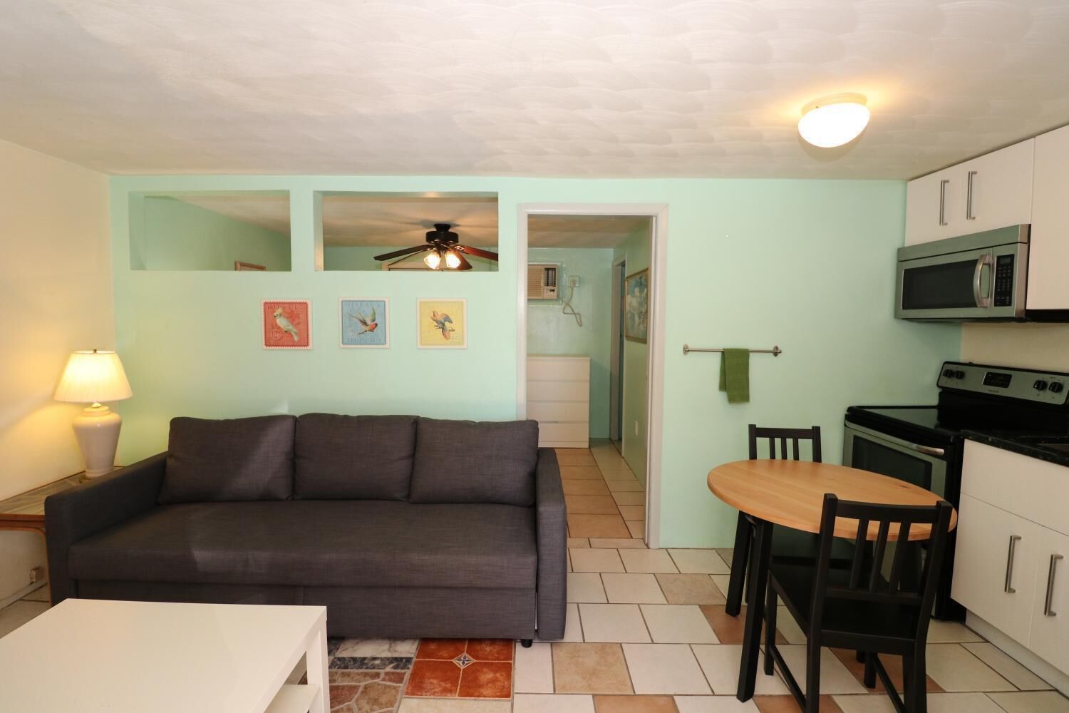 A compact living space with a sofa, a dining table, and a kitchenette.