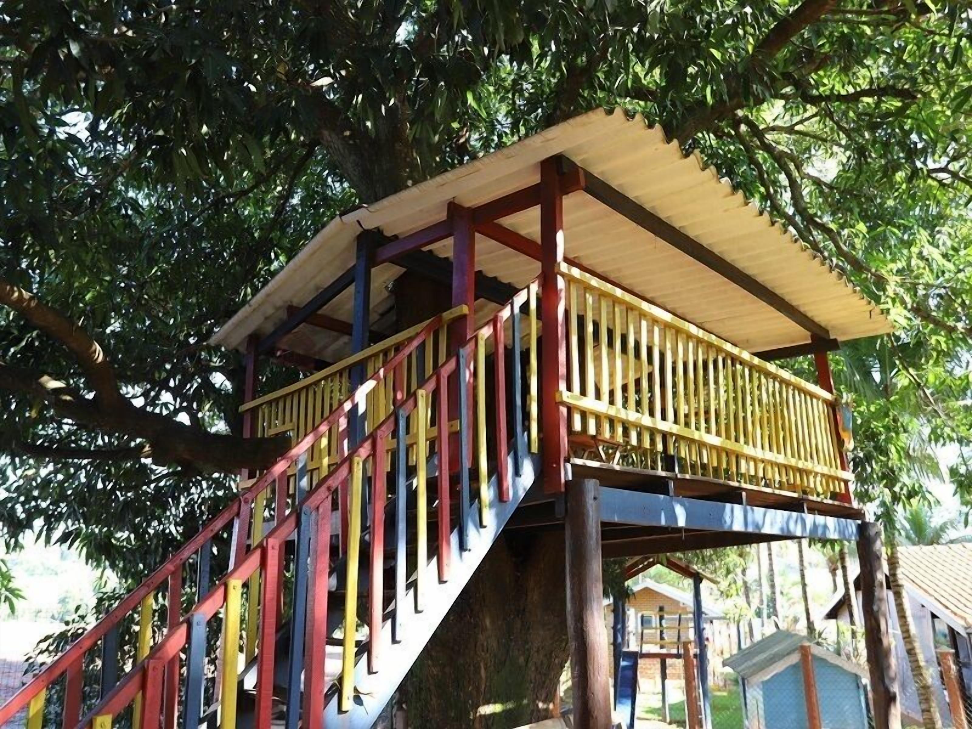 A wooden staircase leading to a covered platform with a railing.